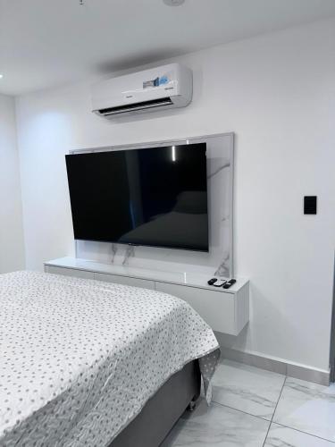 a bedroom with a flat screen tv on a wall at A resort style apartment with ocean views with two bedrooms in Panama City
