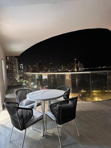 a table and chairs on a balcony with a view at A resort style apartment with ocean views with two bedrooms in Panama City