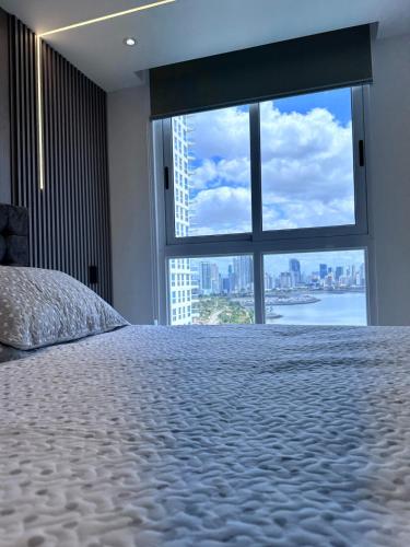 a bedroom with a bed and a large window at A resort style apartment with ocean views with two bedrooms in Panama City
