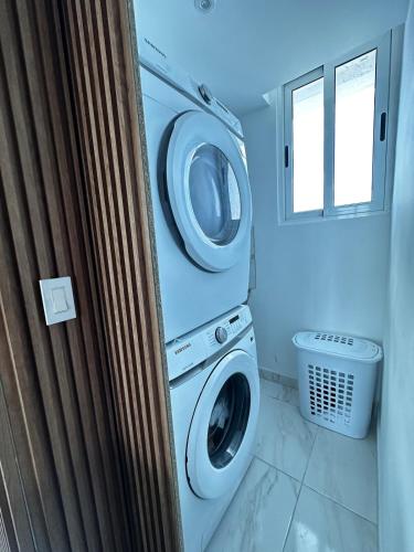 a washing machine and a washer and dryer in a bathroom at A resort style apartment with ocean views with two bedrooms in Panama City