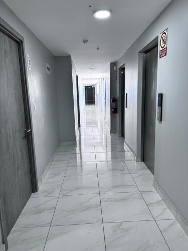 an empty hallway with doors and a tile floor at A resort style apartment with ocean views with two bedrooms in Panama City