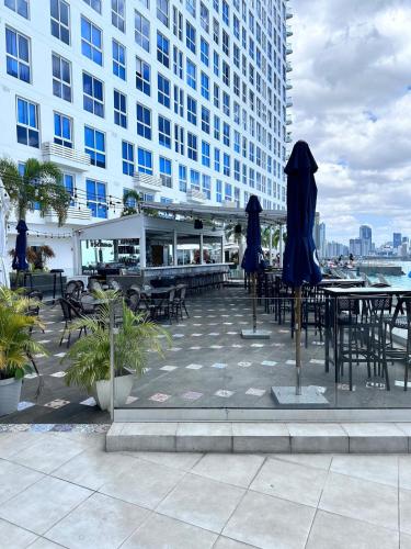 a patio with tables and umbrellas in front of a building at A resort style apartment with ocean views with two bedrooms in Panama City