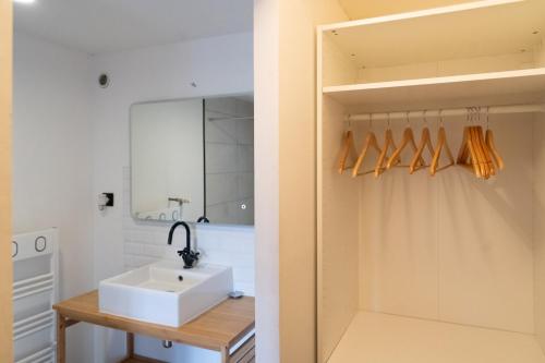 une salle de bain avec un lavabo et un miroir dans l'établissement Appartement 1 chambre, terrasse, proche Tram, à Bordeaux