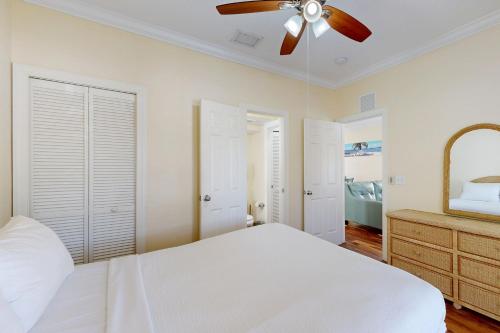 a bedroom with a white bed and a ceiling fan at Hemingway Hideaway in Stock Island