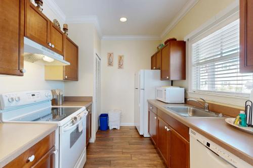 a kitchen with a sink and a white refrigerator at Hemingway Hideaway in Stock Island