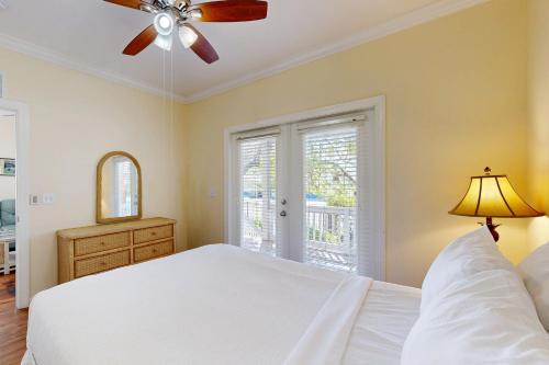a bedroom with a white bed and a ceiling fan at Hemingway Hideaway in Stock Island