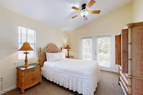 a bedroom with a white bed and a ceiling fan at Hemingway Hideaway in Stock Island