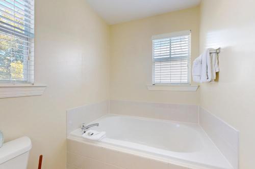 a white bathroom with a tub and a window at Hemingway Hideaway in Stock Island