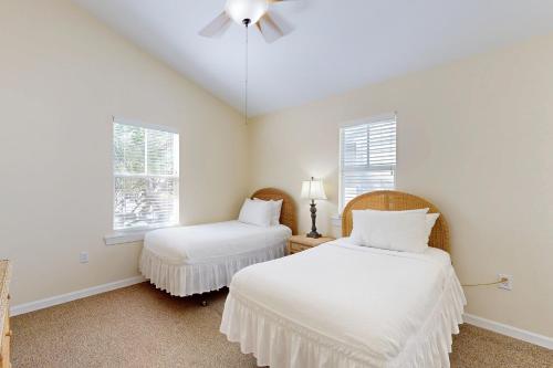 two beds in a room with two windows at Hemingway Hideaway in Stock Island
