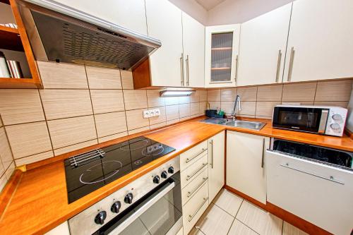a kitchen with white cabinets and a stove top oven at Národní dům Podbořany in Podbořany