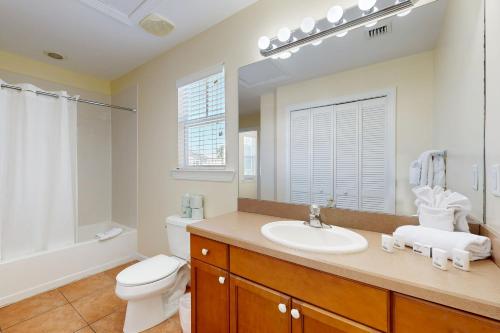 a bathroom with a white toilet and a sink at Hemingway Hideaway in Stock Island