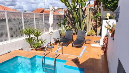 een balkon met een zwembad en 2 stoelen bij BellaVista DM private pool in San Bartolomé