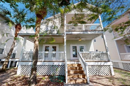 a house with white balconies and palm trees at Hemingway Hideaway in Stock Island
