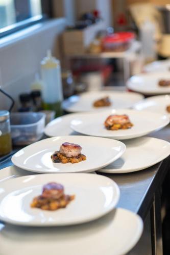 a row of white plates with food on a counter at Morelliana4Rooms in Scansano