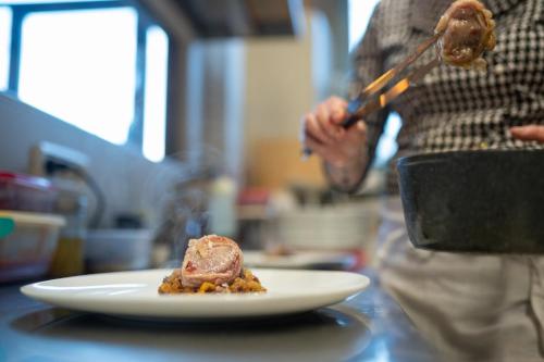 a person is preparing a plate of food on a counter at Morelliana4Rooms in Scansano