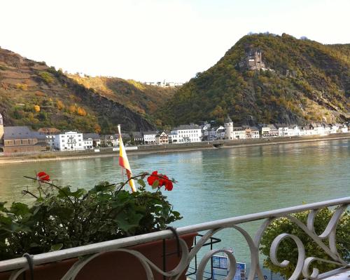 a balcony with a view of a river and a city at Rheinhotel St. Goar in Sankt Goar