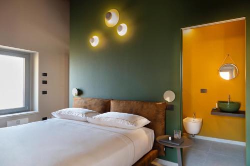a bedroom with a large bed with green and yellow walls at Borgoluna Luxury Holiday House in San Felice del Benaco