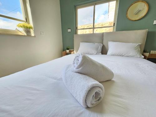 a bedroom with a bed with towels on it at Casa Galilea חופשה גלילית עם בריכה פרטית וג'קוזי in Parod
