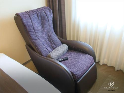 a chair in a hotel room with a blanket on it at Daiwa Roynet Hotel Wakayama in Wakayama