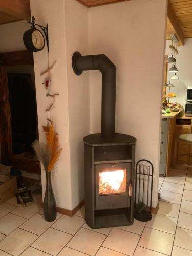 a stove in a living room with a fireplace at Toskanahaus, NJUALMS in Tannheim
