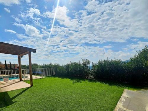 a backyard with a lawn with a gazebo at Casa Galilea חופשה גלילית עם בריכה פרטית וג'קוזי in Parod