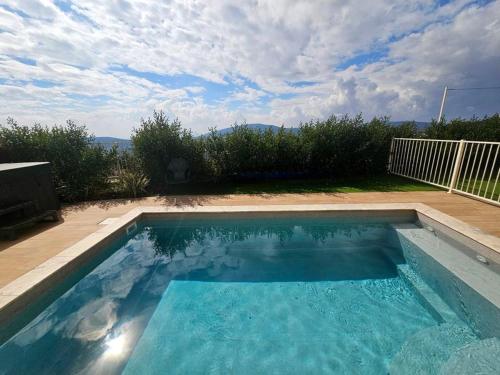 a swimming pool with blue water in a backyard at Casa Galilea חופשה גלילית עם בריכה פרטית וג'קוזי in Parod