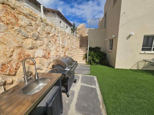 a kitchen with a sink and a stone wall at Casa Galilea חופשה גלילית עם בריכה פרטית וג'קוזי in Parod
