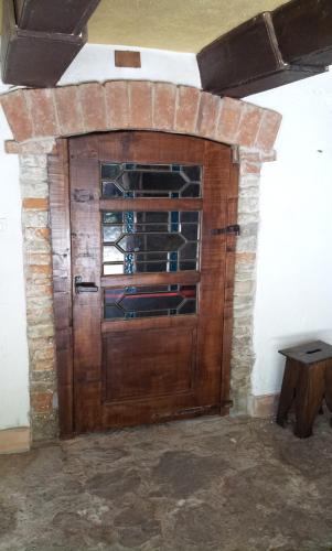 uma porta de madeira num quarto com uma parede de tijolos em B&B I Colori dell'Arcobaleno em Belvedere Langhe