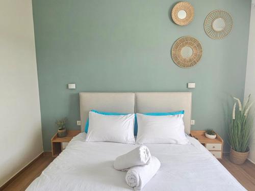a bedroom with a white bed with towels on it at Casa Galilea חופשה גלילית עם בריכה פרטית וג'קוזי in Parod