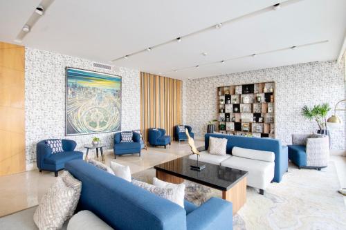 a living room with blue couches and a table at Hotel Velvet Plaza in Guadalajara