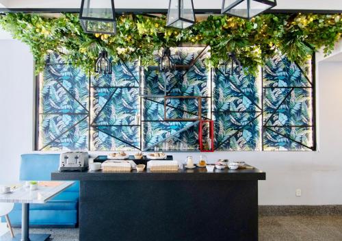 a restaurant with a blue wall with plants at Hotel Velvet Plaza in Guadalajara