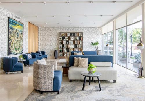 a living room with blue furniture and windows at Hotel Velvet Plaza in Guadalajara