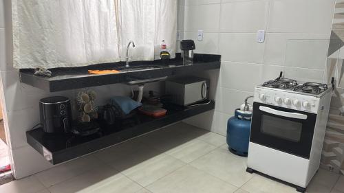 a kitchen with a sink and a stove at Casa temporada 2 in Trindade