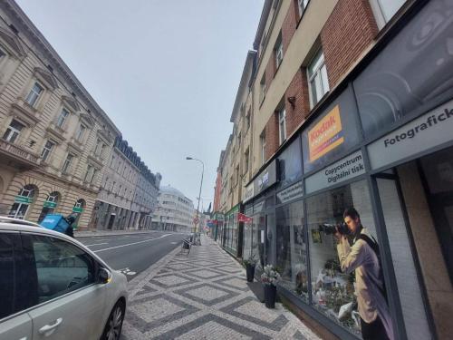 a man taking a picture of a store on a city street at Apartment ČSA #1 in the Historic Center Hradec Králové in Hradec Králové