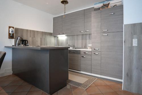 a kitchen with wooden cabinets and a counter top at Haus Biene am Meer in Norden