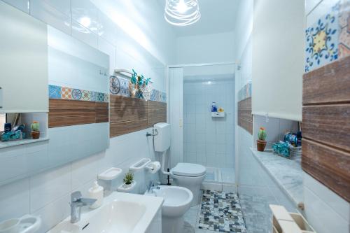 a white bathroom with a toilet and a sink at Casa vacanza Francesca in Leonforte