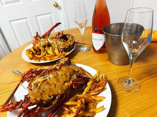a table topped with two plates of food and french fries at Villa Océan Gravier Rodrigues in Mt Bois Noir