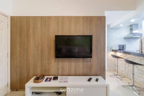 a living room with a tv on a wall at Apto térreo a 5min da Praia do Forte EMA101 in Škorak
