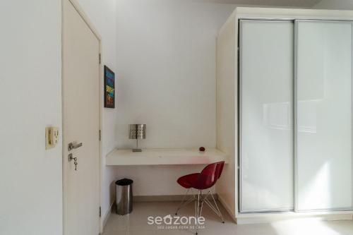 a room with a desk and a red chair at Apto térreo a 5min da Praia do Forte EMA101 in Škorak