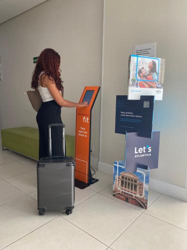 a woman is standing at a sign in a store at Transamerica Fit Campinas in Campinas