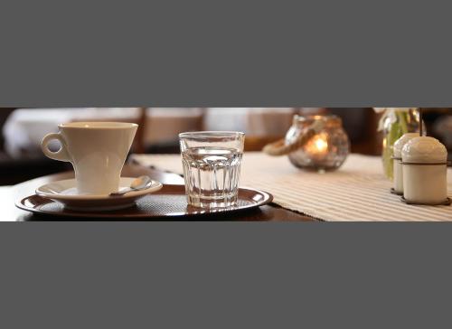 a cup of water and a glass on a table at Antonio Old Town Residence in Prešov