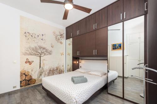 une chambre avec un lit et un ventilateur de plafond dans l'établissement MASSENA - Agréable 3 pièces - Plein coeur de Menton, à Menton