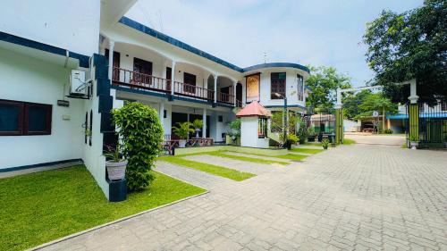 a courtyard of a building with green grass at Hotel Milenium in Kurundankulama