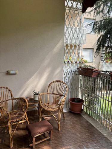 a porch with chairs and a table and a fence at Appartamento zona Rho Fiera in Arese