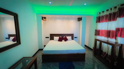 a bedroom with a bed with a green ceiling at Hotel Milenium in Kurundankulama