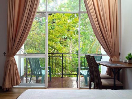 a room with a large window and a table and chairs at Zeleny Retreat Home Stay in Matara