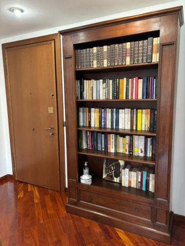 a book shelf filled with books next to a door at Appartamento zona Rho Fiera in Arese