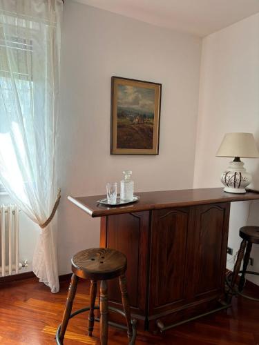 a wooden desk in a room with two stools at Appartamento zona Rho Fiera in Arese