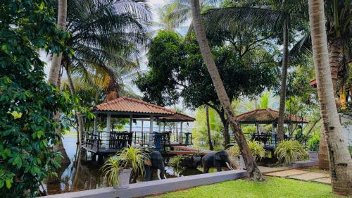 two elephants standing in front of a house with trees at Hotel Milenium in Kurundankulama