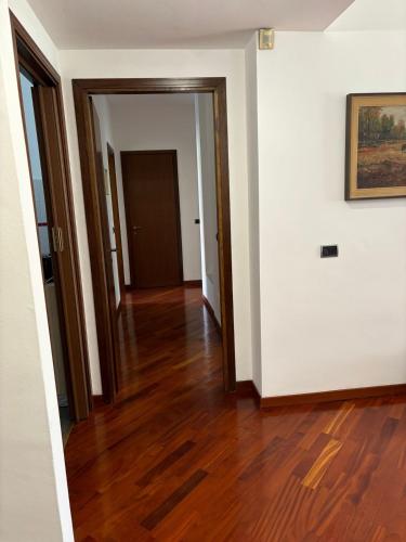 an empty hallway with wood floors and a painting at Appartamento zona Rho Fiera in Arese